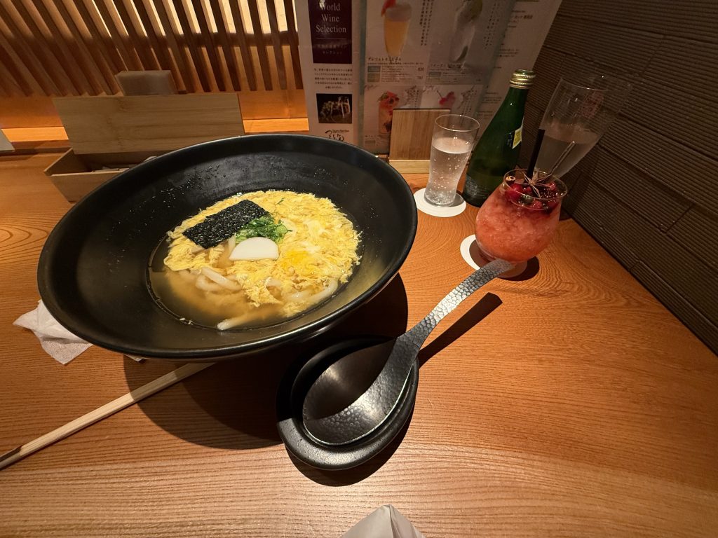 a bowl of udon at a noodle shop bar, made for solo travelers in Tokyo